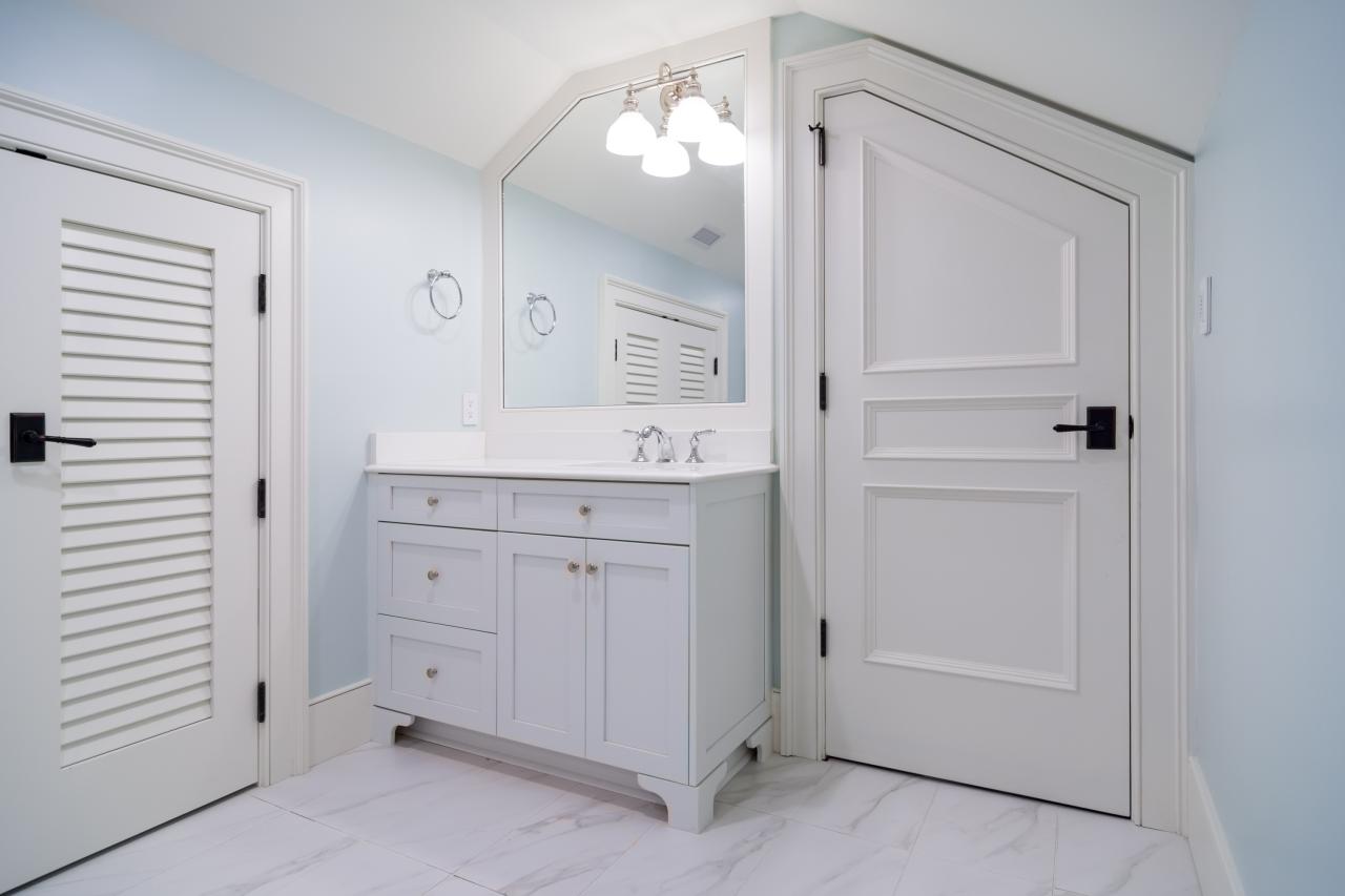 A clipped-corner TS3070 door fits the unique ceiling of this attic powder room. Pair of LVR1000 doors to the left.