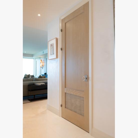 This modified TS2210 door, in wire-brushed plain sawn white oak with customer applied ceruse finish and Shagreen Grey Oyster leather, features olive knuckle hinges.