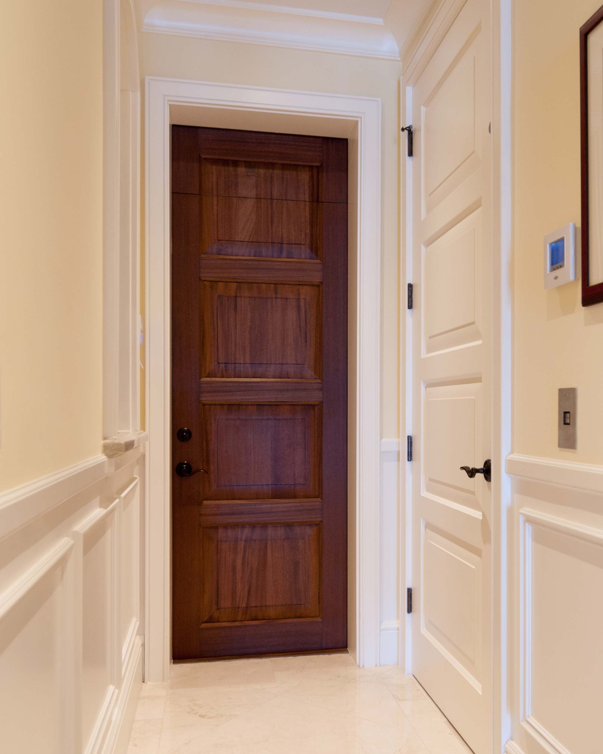 Two TS4100 doors in a hallway. A mahogany panel door in the center and a MDF door on the right.