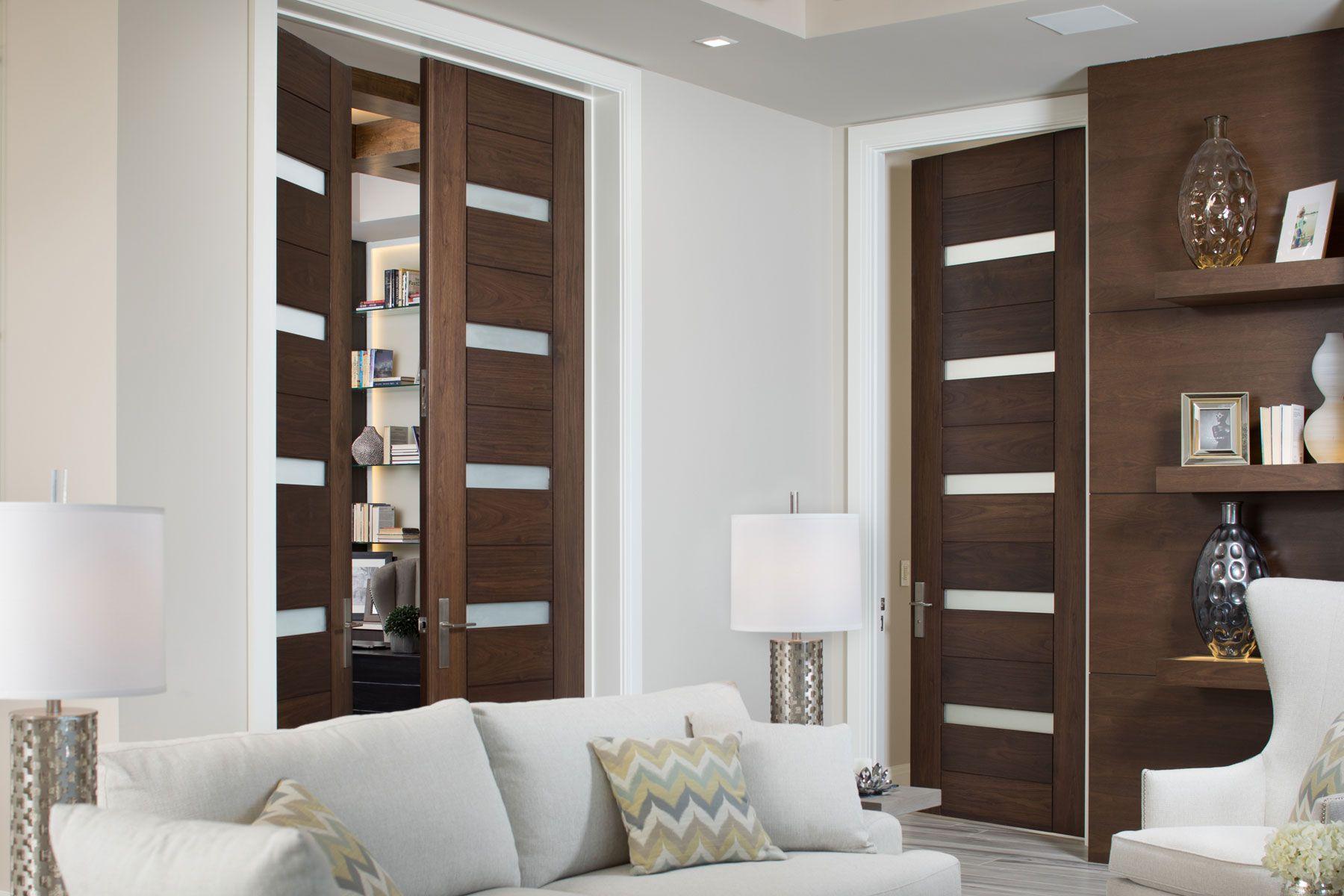 three dark artistic barn doors with four frosted glass inserts next to sofa