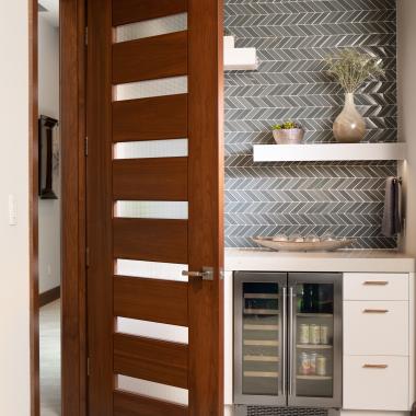 A TM9350 door in walnut with Nutmeg stain and Dash glass opens to a guest suite