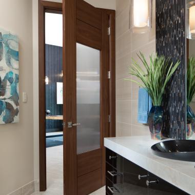 A TM9250 door, in walnut with Nutmeg stain and Groove glass, divides a bathroom from this contemporary study.