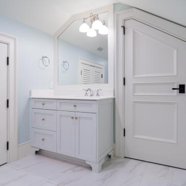 A clipped-corner TS3070 door fits the unique ceiling of this attic powder room. Pair of LVR1000 doors to the left.