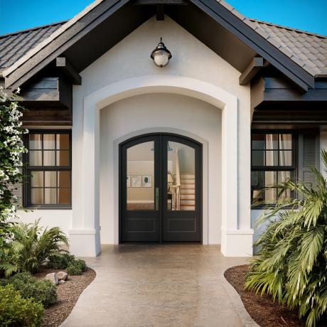 FL112-ES501 Resilient Wood Entry System with Cove & Bead sticking, raised panels, and clear glass, featured in an arched double-door entry on a modern style home