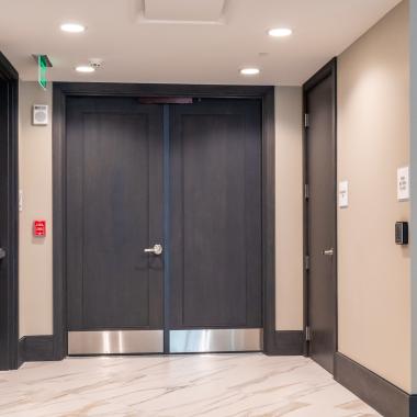 Condominium tower featuring TS1000 doors, in rift sawn white oak with Quirk (QM) moulding and Flat (C) panel in lobby.