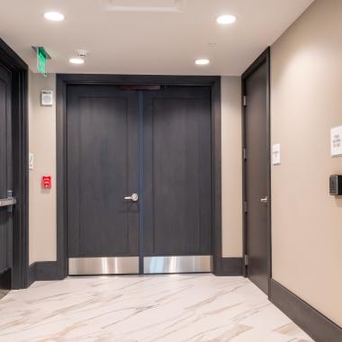 Condominium tower featuring TS1000 doors, in rift sawn white oak with Quirk (QM) moulding and Flat (C) panel in lobby.