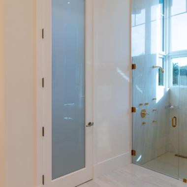 This master bath features 10' tall TS1000 door in MDF with One Step sticking and White Lami glass