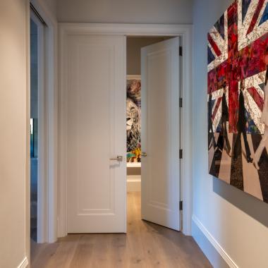A pair of TS1000 doors, in MDF with Miracle (MR) moulding and flat (C) panel, separate a master bedroom suite from the rest of the home.
