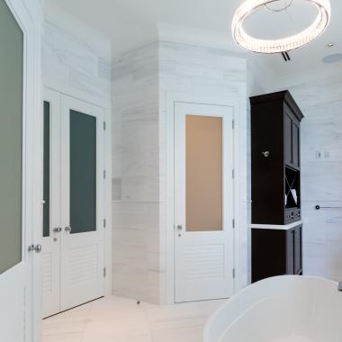 A master bath features TS2060 doors in MDF with Roman Ogee (OG) sticking, Raised (A) panel and Frosted Glass. The bottom panels have been replaced with false louver panels.