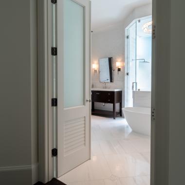 A master bath features TS2060 doors in MDF with Roman Ogee (OG) sticking, Raised (A) panel and Frosted Glass. The bottom panels have been replaced with false louver panels.