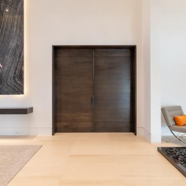 A pair of TMIR3080 pocket doors, in quarter sawn white oak with ¼" kerf cut reveals, open to a family room. Builder provided stain finish.