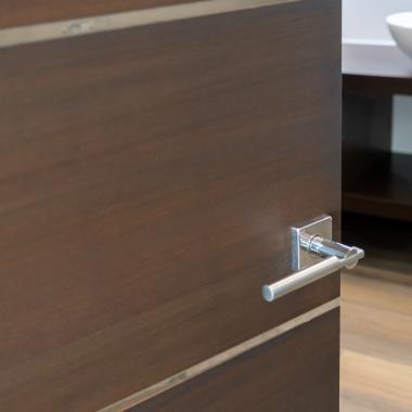 An attached bathroom features TMIR6000 doors in mahogany with ½" bright stainless steel inlay. Builder provided stain finish.