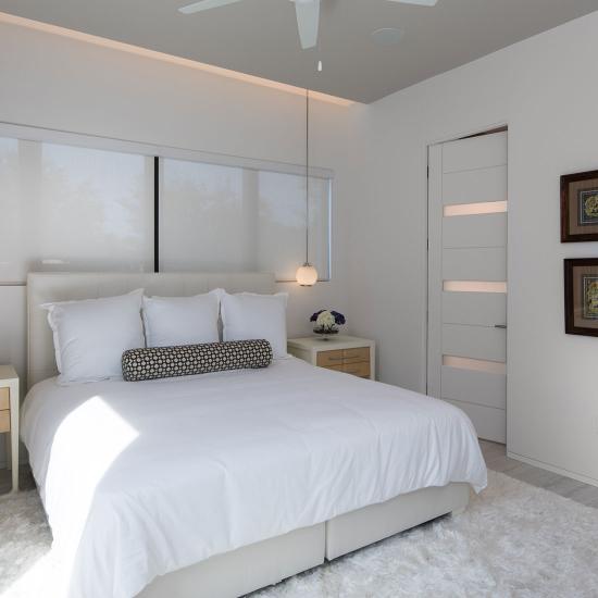 TM9320 doors with White Lami glass add a modern finish to this guest room 