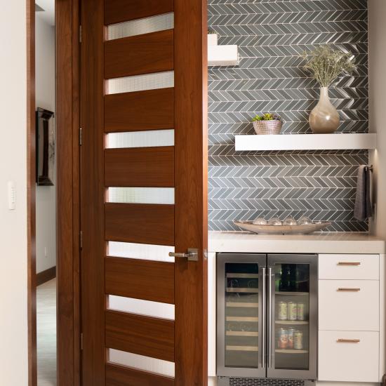 A TM9350 door in walnut with Nutmeg stain and Dash glass opens to a guest suite