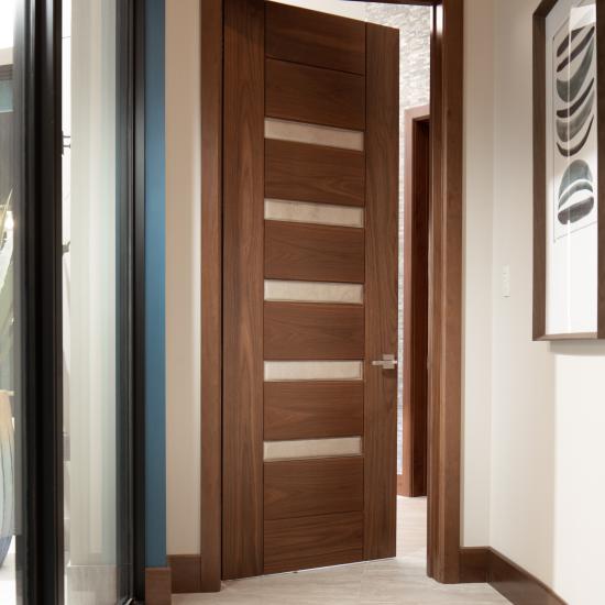 A TM9340 door, in walnut with Nutmeg stain and Shagreen Café Latte leather, opens to a large study which doubles as a guest room.