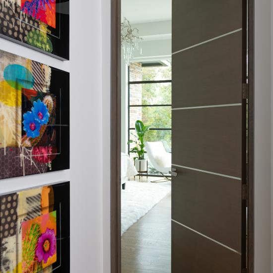 Bedroom featuring a TMIR5000 door in quarter sawn white oak with Grey Mist stain and ½" bright stainless steel inlays.