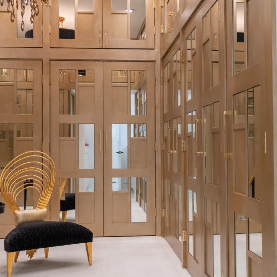 The designer added glamour to this walk-in closet by custom applying plant-ons and mirrors to TS3000 doors in MDF.