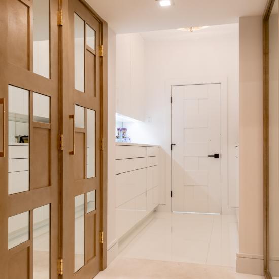 The designer added glamour to this walk-in closet by custom applying plant-ons and mirrors to TS3000 doors in MDF.