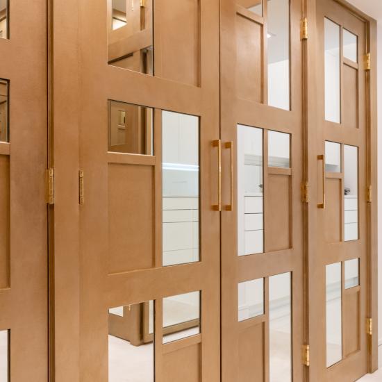 The designer added glamour to this walk-in closet by custom applying plant-ons and mirrors to TS3000 doors in MDF.