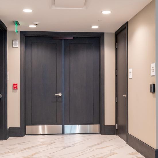 Condominium tower featuring TS1000 doors, in rift sawn white oak with Quirk (QM) moulding and Flat (C) panel in lobby.