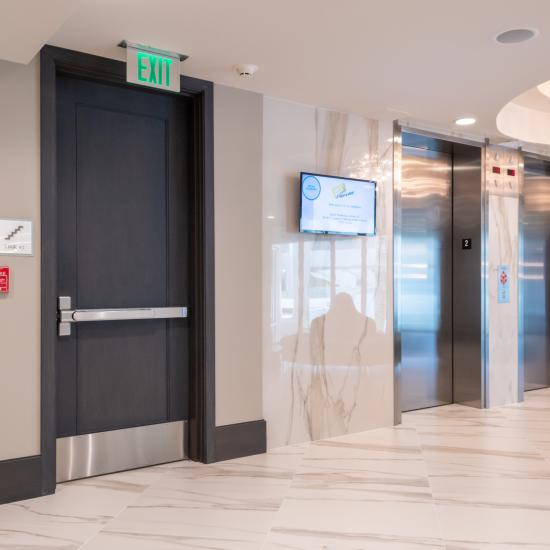 Condominium tower featuring TS1000 doors, in rift sawn white oak with Quirk (QM) moulding and Flat (C) panel in lobby.