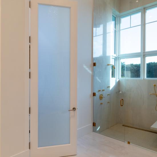 This master bath features 10' tall TS1000 door in MDF with One Step sticking and White Lami glass