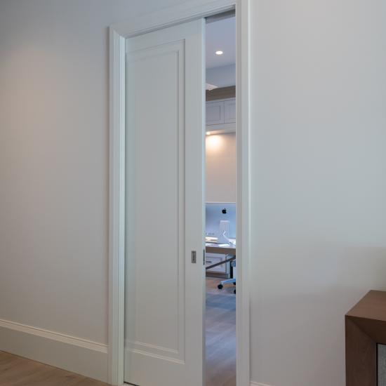 A TS1000 pocket door, in MDF with Miracle (MR) moulding and flat (C) panel, opens from the master bedroom to a private office.