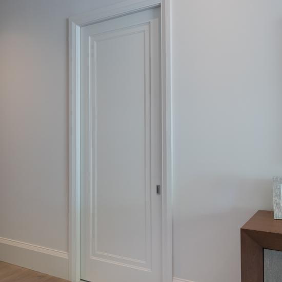 A TS1000 pocket door, in MDF with Miracle (MR) moulding and flat (C) panel, opens from the master bedroom to a private office.