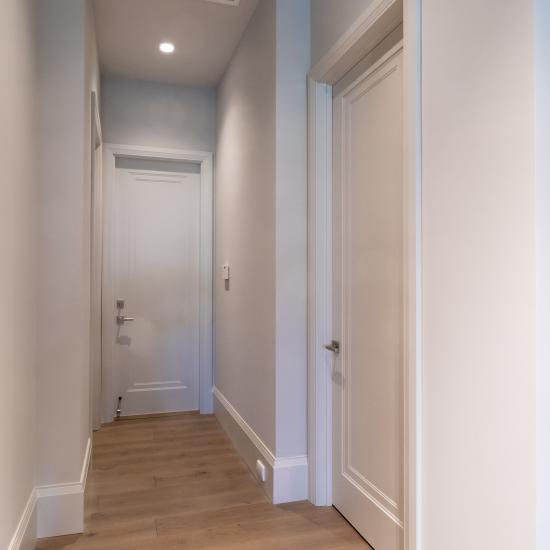 A hallway with TS1000 doors, in MDF with Miracle (MR) moulding and Flat (C) panel lead downs to the garage.