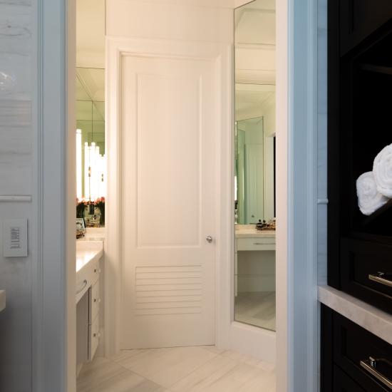 A master bath features TS2060 doors in MDF with Roman Ogee (OG) sticking, Raised (A) panel and Frosted Glass. The bottom panels have been replaced with false louver panels.