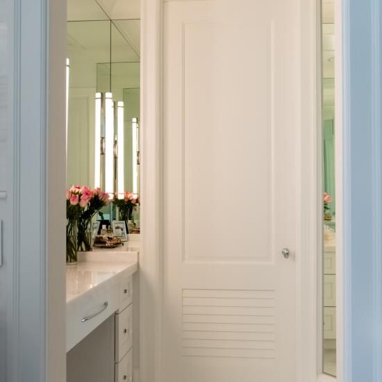 A master bath features TS2060 doors in MDF with Roman Ogee (OG) sticking, Raised (A) panel and Frosted Glass. The bottom panels have been replaced with false louver panels.