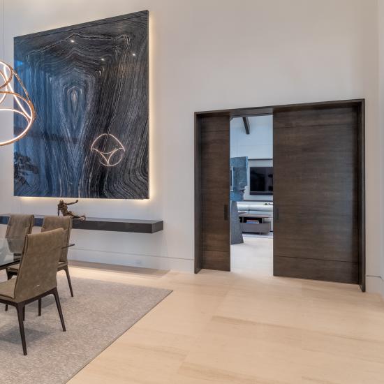 A pair of TMIR3080 pocket doors, in quarter sawn white oak with ¼" kerf cut reveals, open to a family room. Builder provided stain finish.