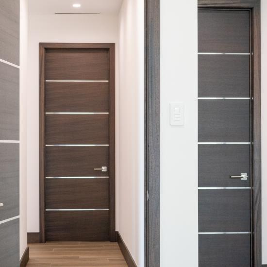 This bedroom features TMIR6000 doors in mahogany with ½" bright stainless steel inlay. Builder provided stain finish.