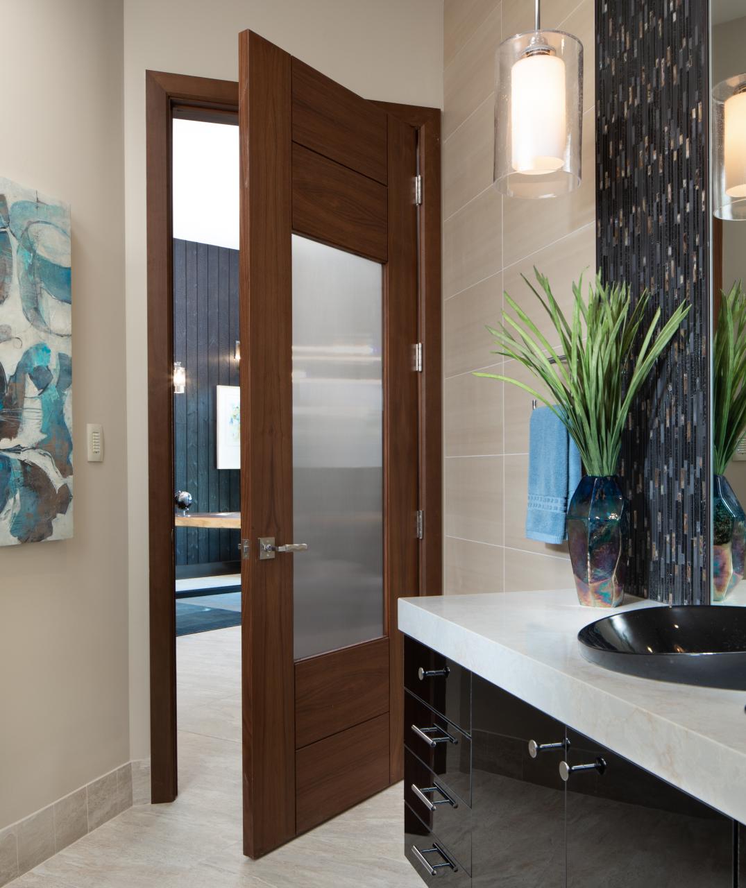 A TM9250 door, in walnut with Nutmeg stain and Groove glass, divides a bathroom from this contemporary study.