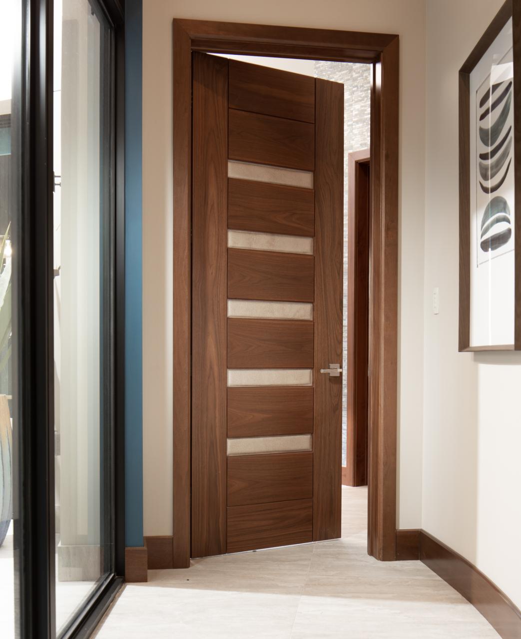 A TM9340 door, in walnut with Nutmeg stain and Shagreen Café Latte leather, opens to a large study which doubles as a guest room.