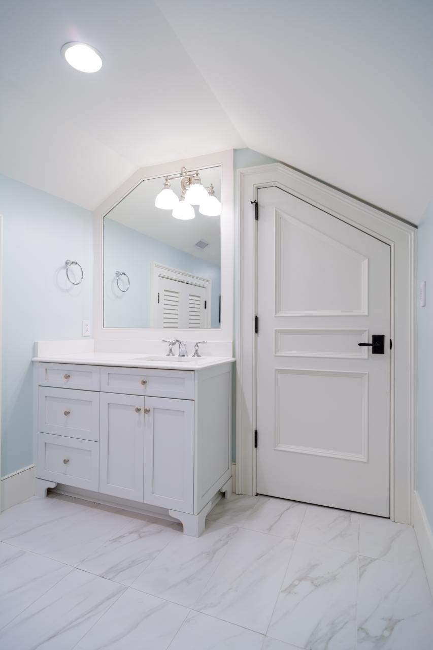 A clipped-corner TS3070 door fits the unique ceiling of this attic powder room.