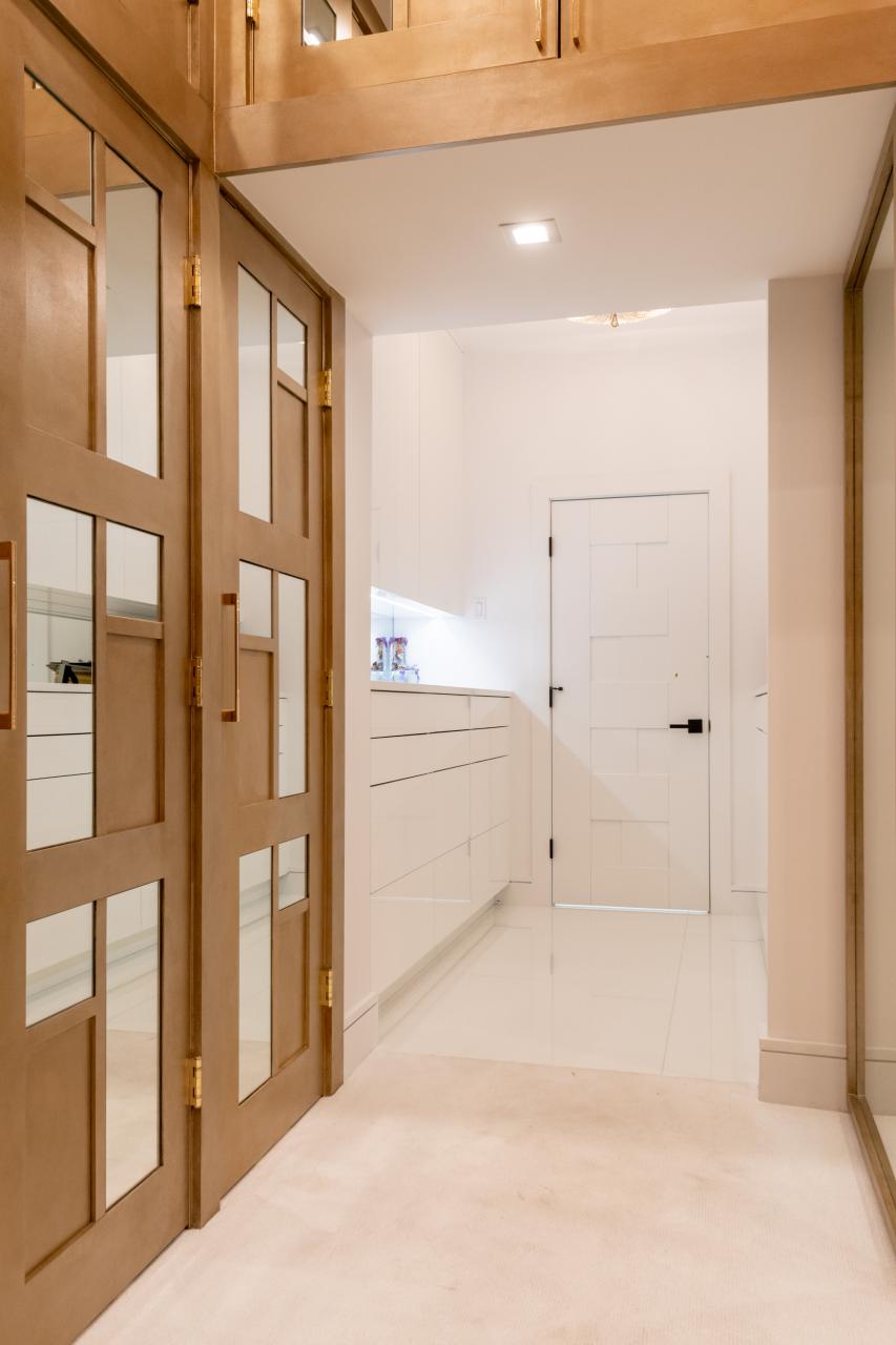 The designer added glamour to this walk-in closet by custom applying plant-ons and mirrors to TS3000 doors in MDF.