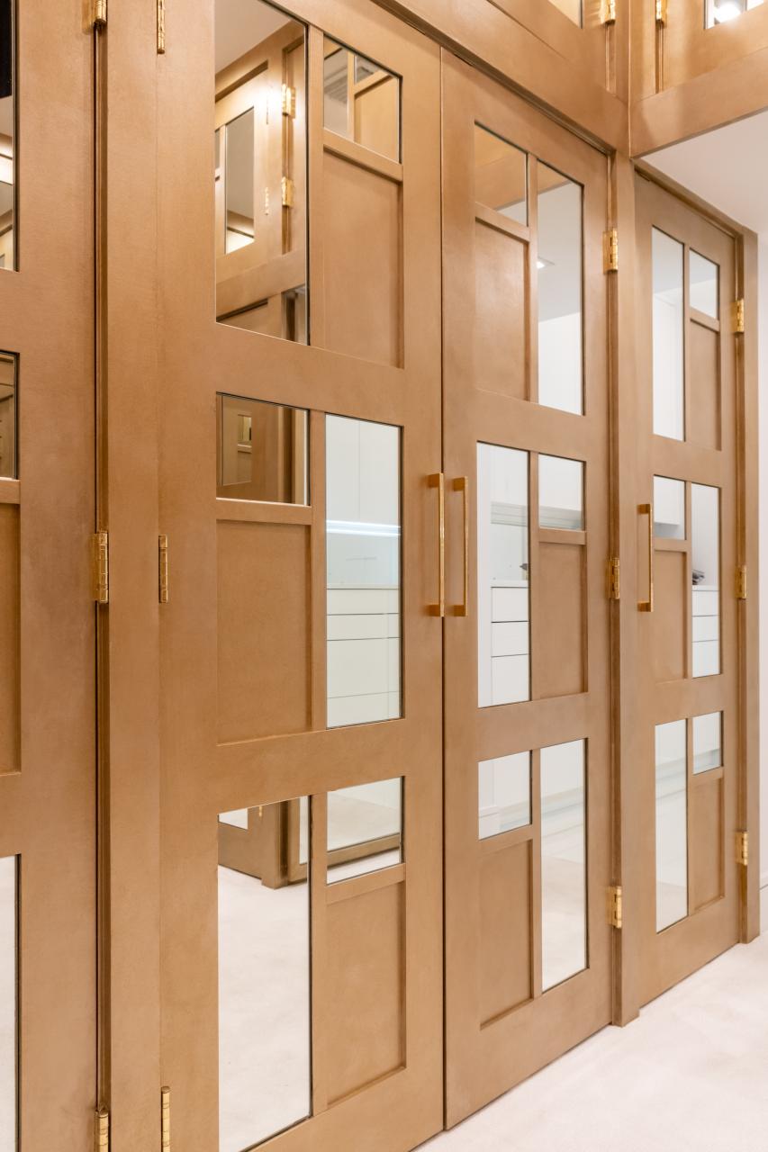 The designer added glamour to this walk-in closet by custom applying plant-ons and mirrors to TS3000 doors in MDF.