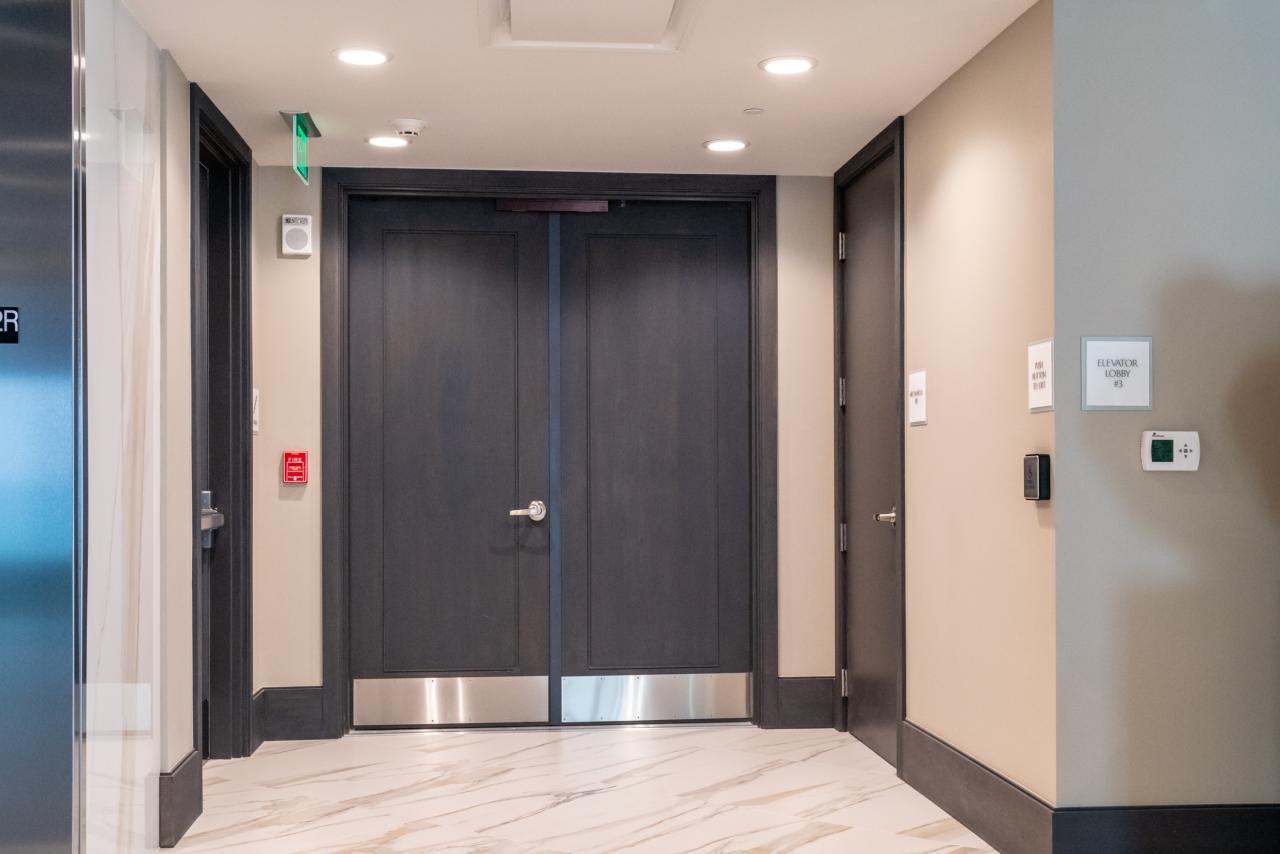 Condominium tower featuring TS1000 doors, in rift sawn white oak with Quirk (QM) moulding and Flat (C) panel in lobby.