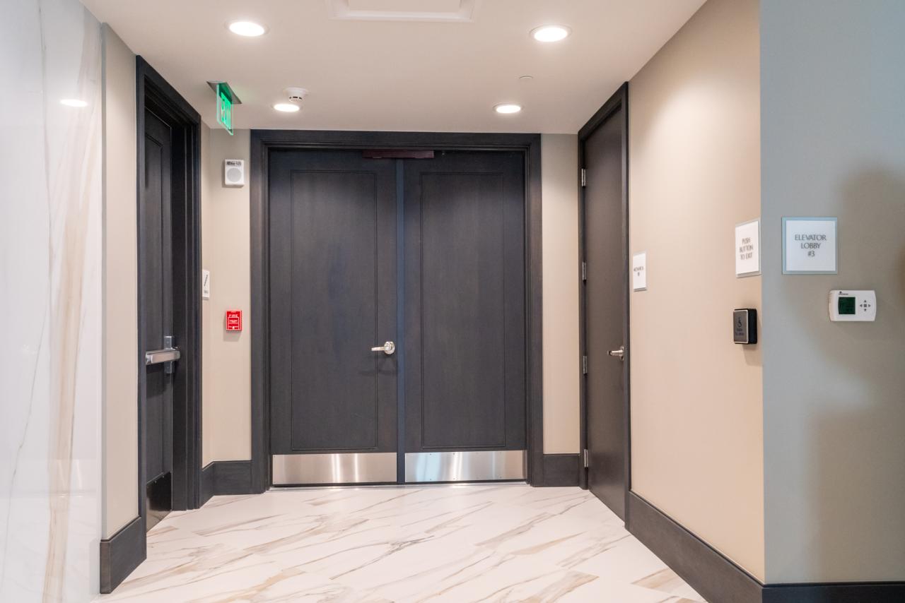 Condominium tower featuring TS1000 doors, in rift sawn white oak with Quirk (QM) moulding and Flat (C) panel in lobby.