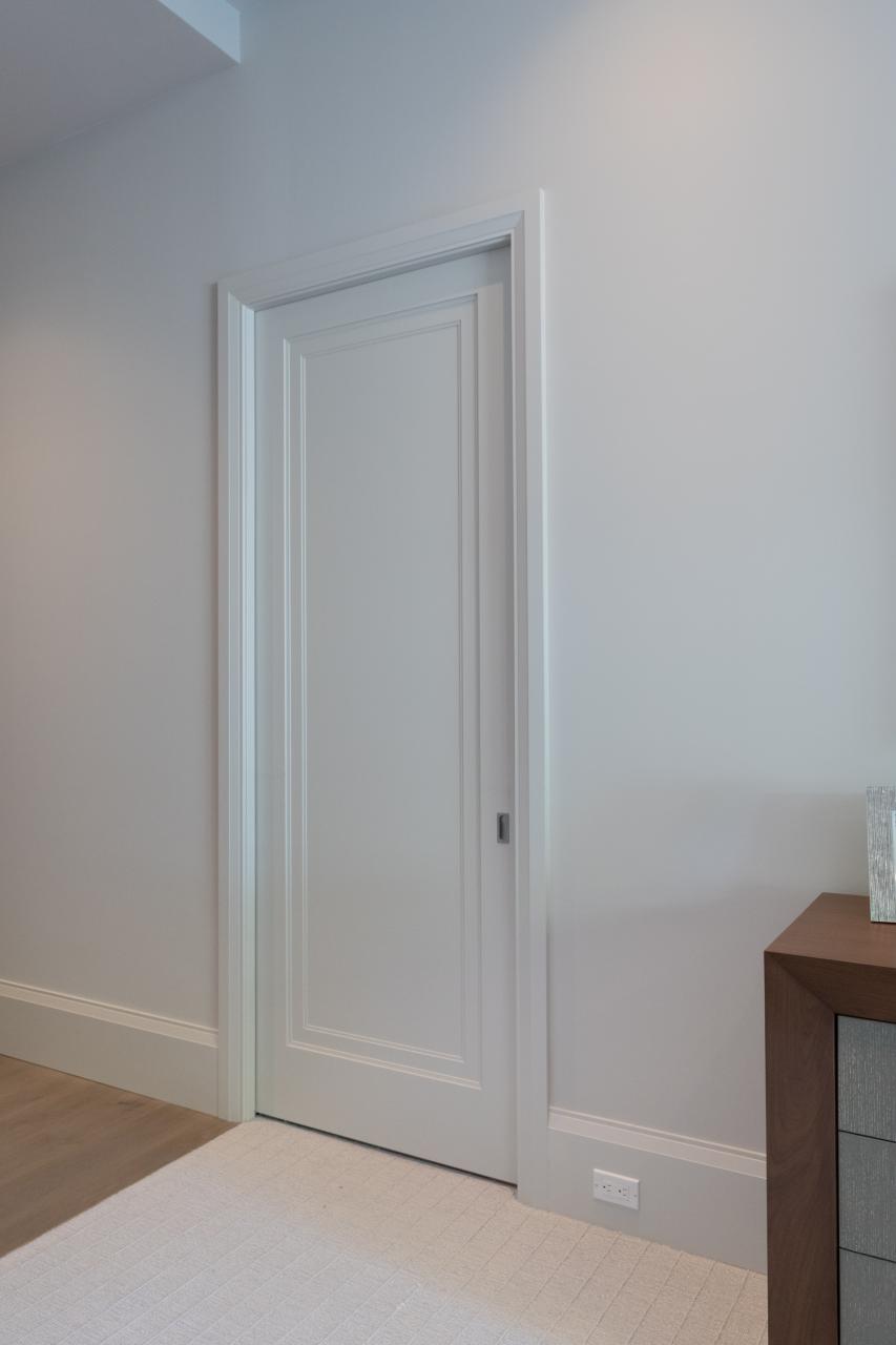 A TS1000 pocket door, in MDF with Miracle (MR) moulding and flat (C) panel, opens from the master bedroom to a private office.