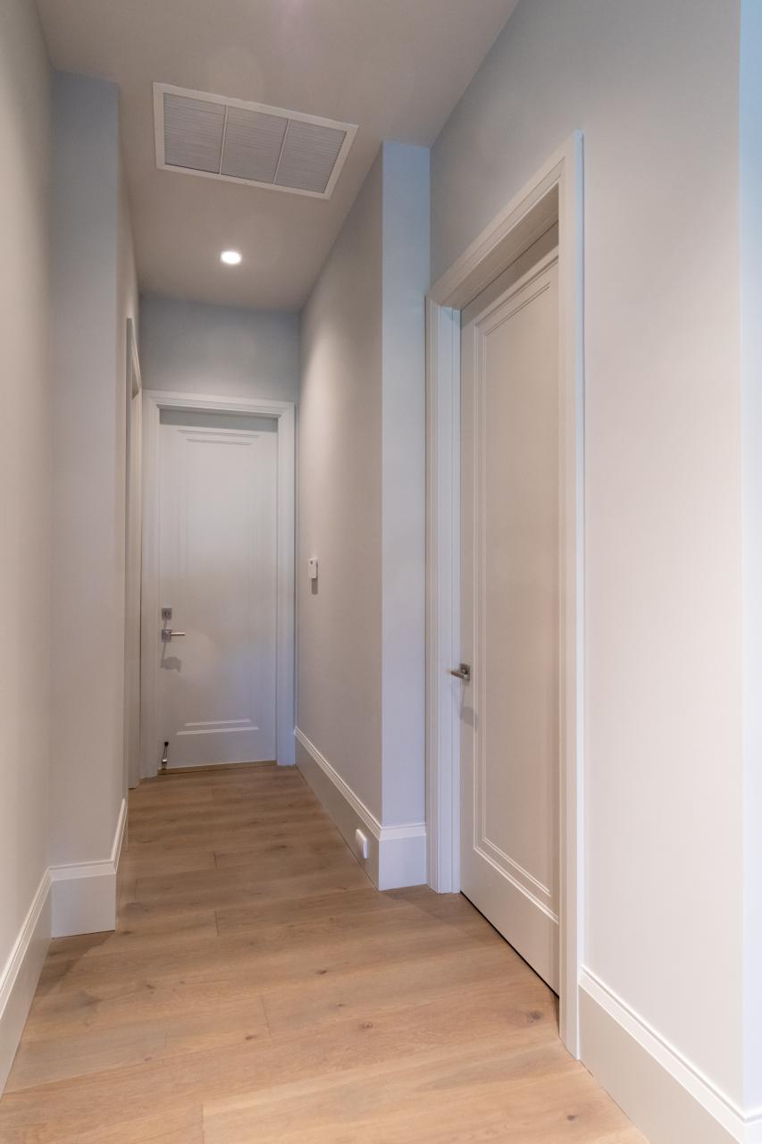 A hallway with TS1000 doors, in MDF with Miracle (MR) moulding and Flat (C) panel lead downs to the garage.