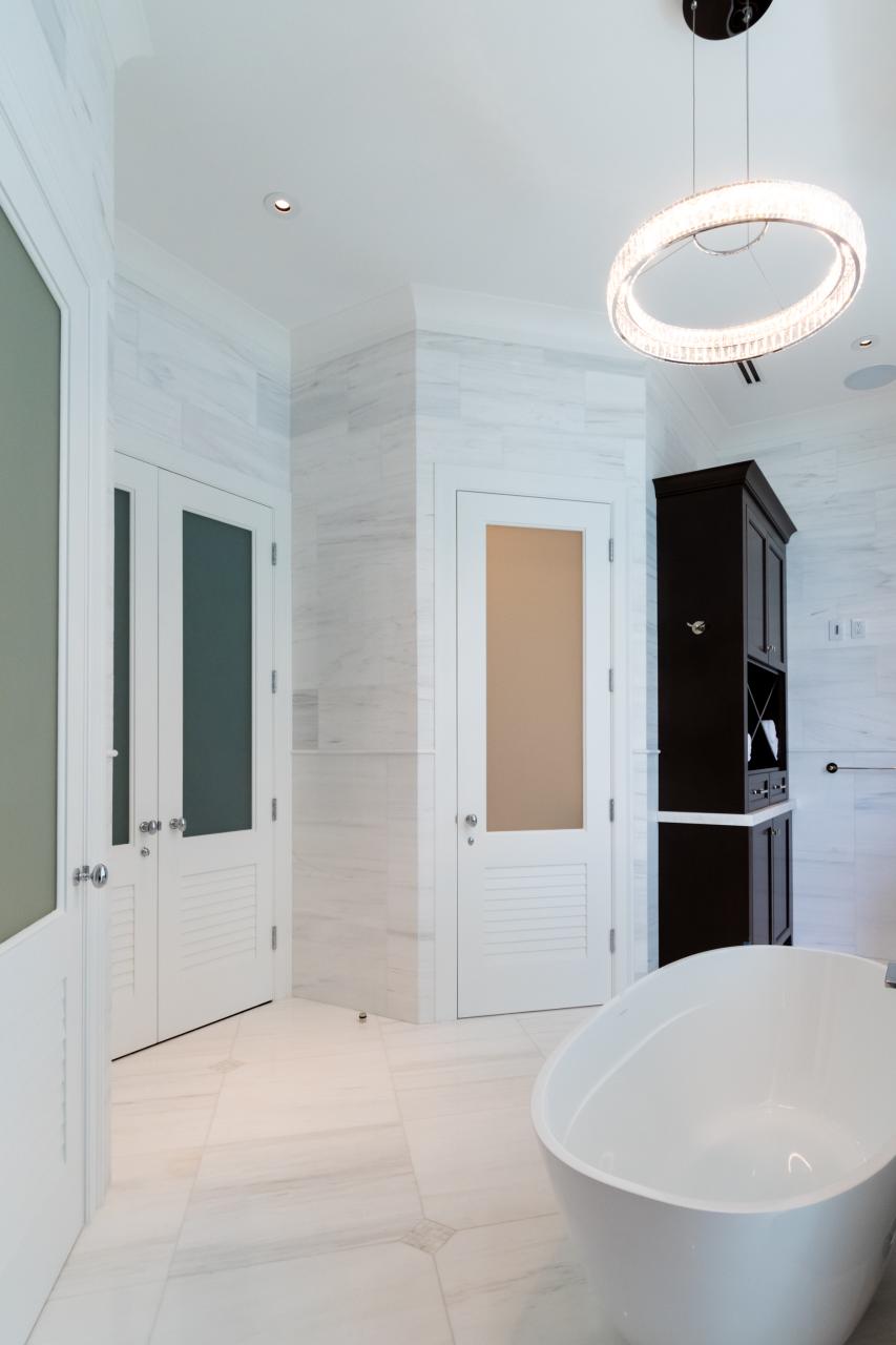 A master bath features TS2060 doors in MDF with Roman Ogee (OG) sticking, Raised (A) panel and Frosted Glass. The bottom panels have been replaced with false louver panels.