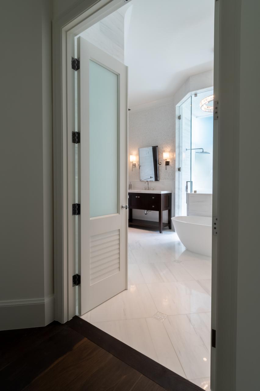 A master bath features TS2060 doors in MDF with Roman Ogee (OG) sticking, Raised (A) panel and Frosted Glass. The bottom panels have been replaced with false louver panels.