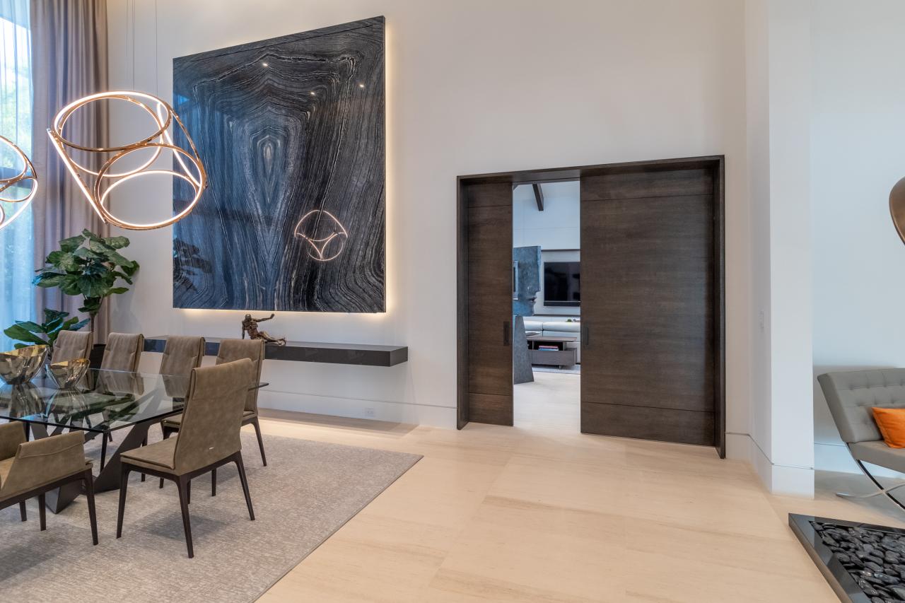 A pair of TMIR3080 pocket doors, in quarter sawn white oak with ¼" kerf cut reveals, open to a family room. Builder provided stain finish.