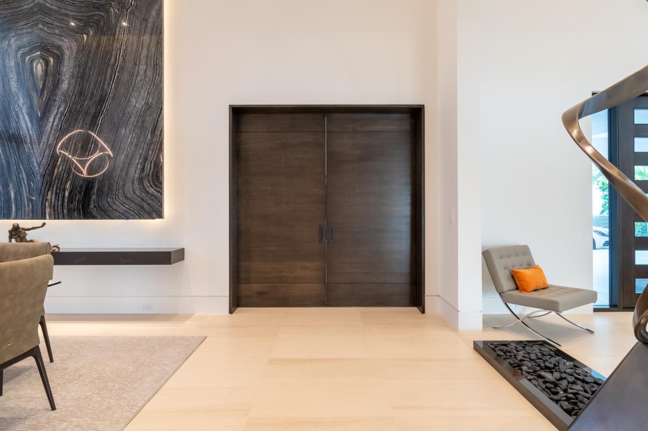 A pair of TMIR3080 pocket doors, in quarter sawn white oak with ¼" kerf cut reveals, open to a family room. Builder provided stain finish.