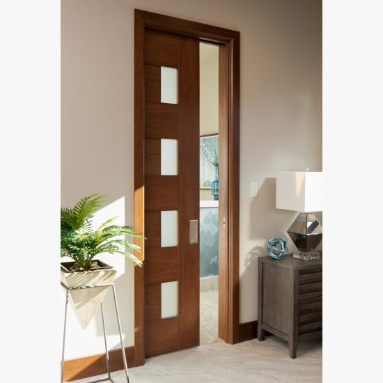 A TM9400 door, in walnut with Nutmeg stain and Frosted glass, divides the bathroom from the rest of this guest suite