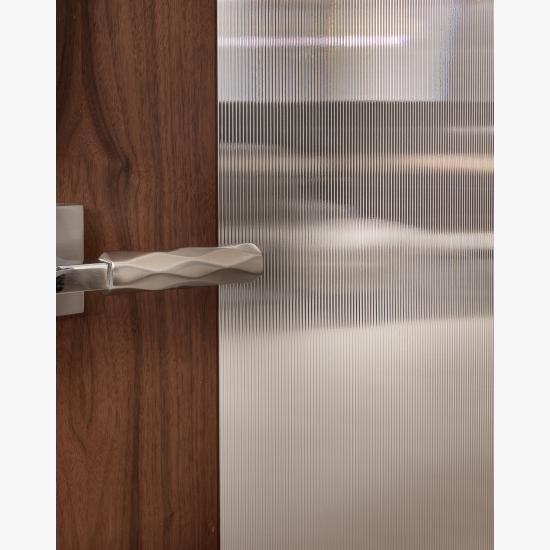 A TM9250 door, in walnut with Nutmeg stain and Groove glass, divides a bathroom from this contemporary study.