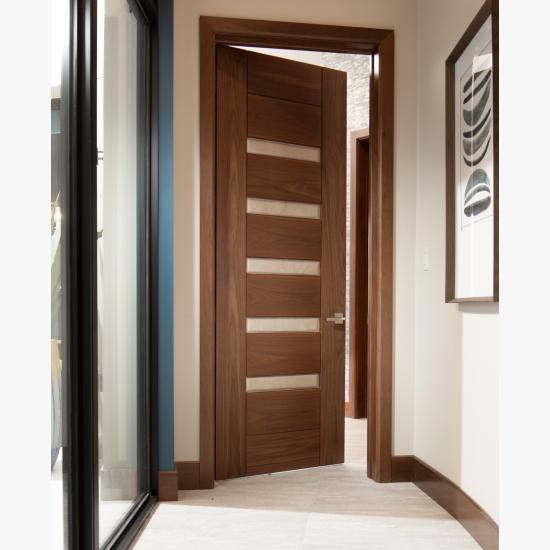 A TM9340 door, in walnut with Nutmeg stain and Shagreen Café Latte leather, opens to a large study which doubles as a guest room.