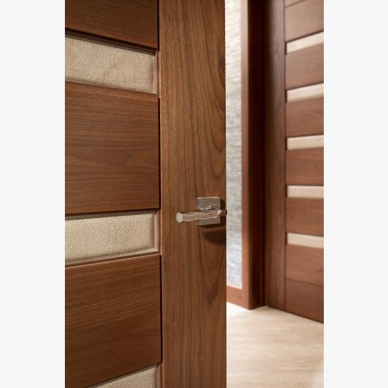 A TM9340 door, in walnut with Nutmeg stain and Shagreen Café Latte leather, opens to a large study which doubles as a guest room.